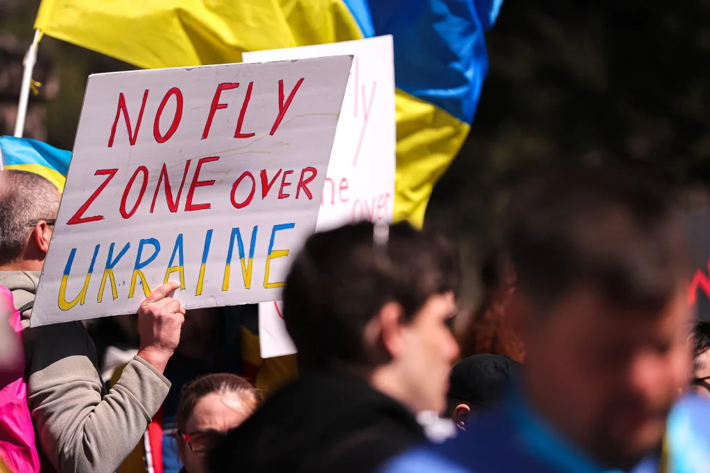 This image has an empty alt attribute; its file name is a-protester-holds-up-a-sign-calling-for-nato-to-create-a-no-fly-zone-over-ukraine-1024x683.webp