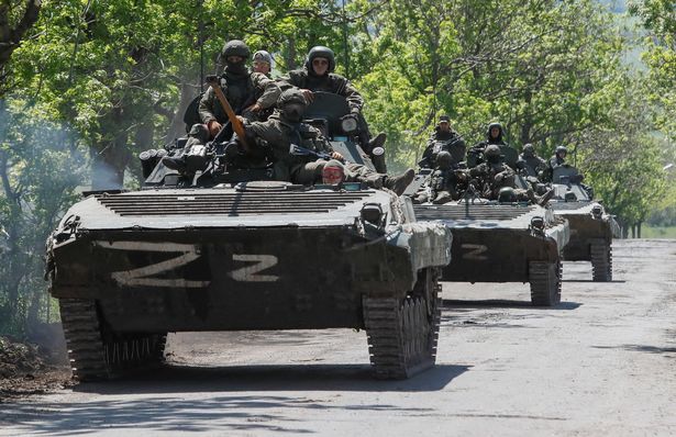 This image has an empty alt attribute; its file name is 1_A-convoy-of-Russian-armoured-vehicles-drives-along-a-road-near-Mariupol.jpg