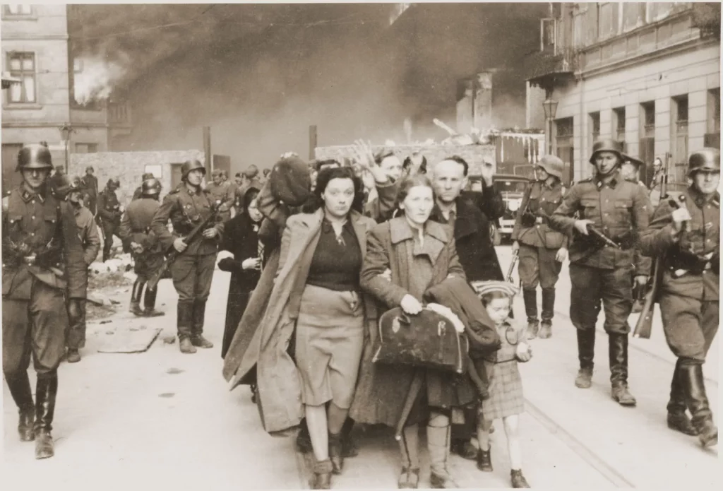 This image has an empty alt attribute; its file name is family-marching-Jews-head-column-way-Warsaw-1943-1024x695.webp